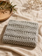 Folded view of the taupe-grey crochet tunic highlighting its alternating openwork rows and subtle metallic finish.
