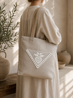 Styling example showing the white triangular crochet lace motif applied to a neutral fabric tote bag.