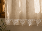 Styling example showing a row of white triangular crochet lace motifs along the lower edge of a curtain