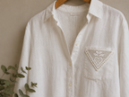 Styling example showing the small white crochet lace motif applied to the chest of a white shirt.