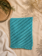 Detailed flat view of the turquoise crochet fabric showing alternating openwork rows and diagonal stitch direction.