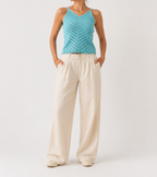 Front studio view of the turquoise openwork crochet top showing the V-neck, slim straps and diagonal stitch pattern.