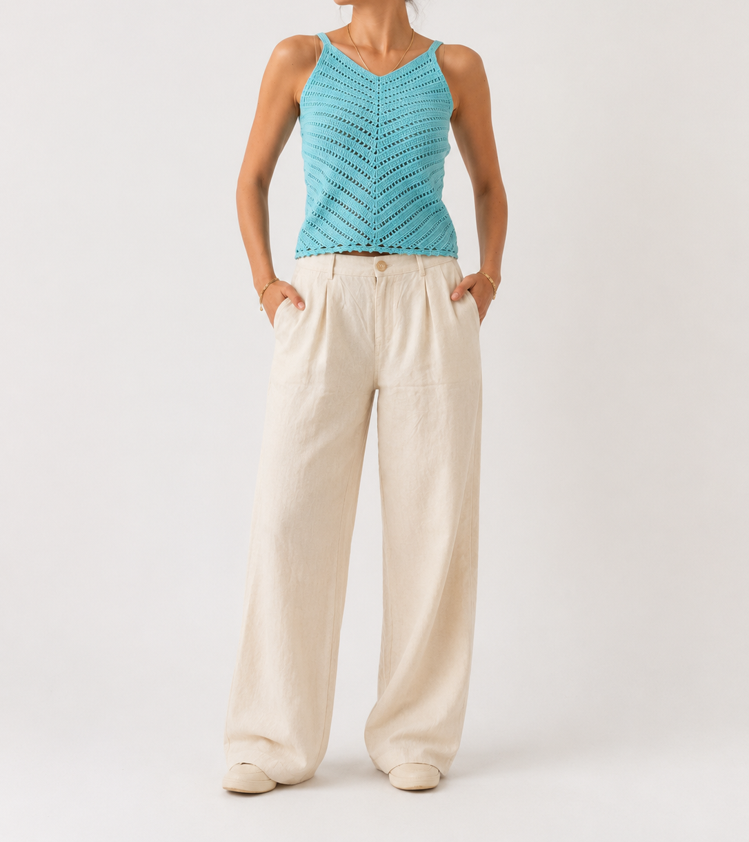 Front studio view of the turquoise openwork crochet top showing the V-neck, slim straps and diagonal stitch pattern.
