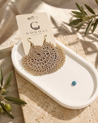 Warm sand-beige crochet earring presented beside a GOGOLI jewellery card on a white decorative tray.