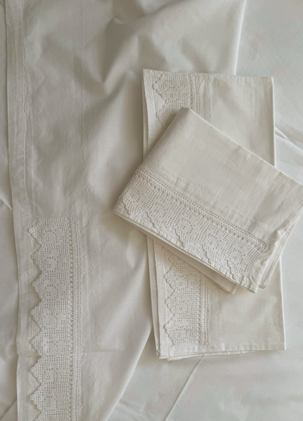 Close-up of the plain-weave white cotton fabric, handmade crochet lace and decorative piko-sarma finishing.