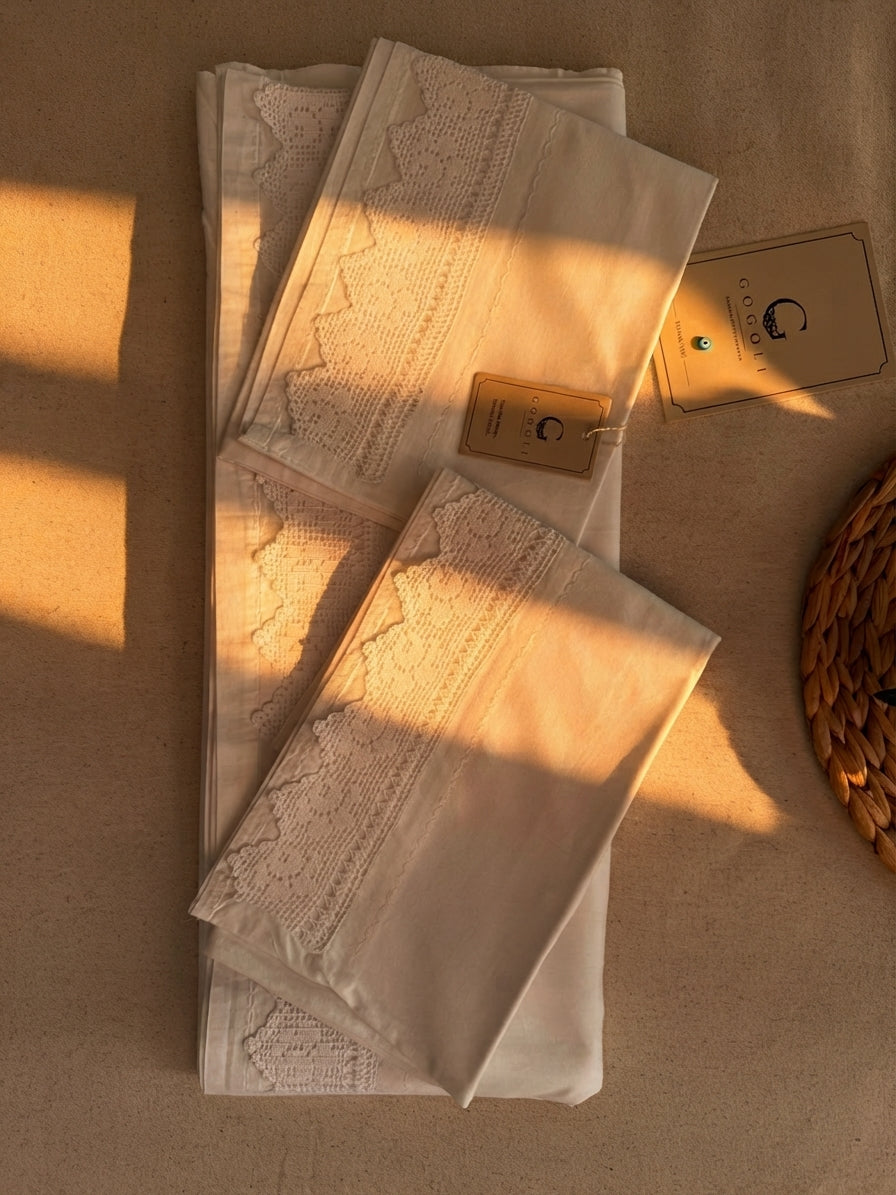 Close view of the white cotton sheet showing the 8 cm crochet lace section inset from the outer edge.