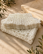 Stacked white cotton crochet pieces from the seventeen-piece table-linen set, showing the repeated floral lace pattern.