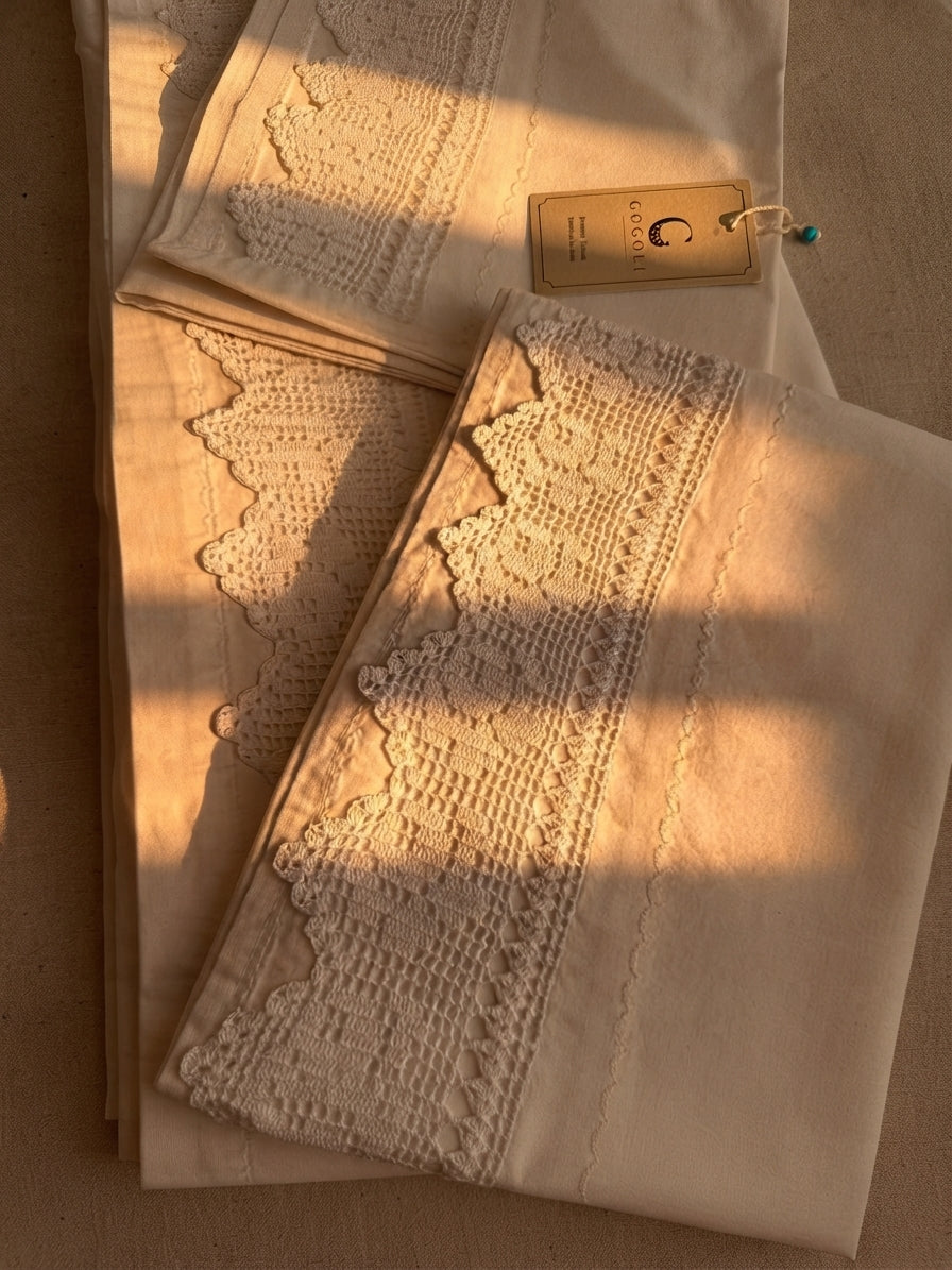 Folded white cotton bed linen set showing the crochet lace placement and clean piko-sarma finished edges.