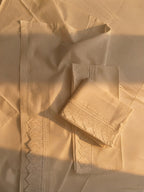 Detail of the white cotton pillowcase showing inset handmade crochet lace along the opening side.