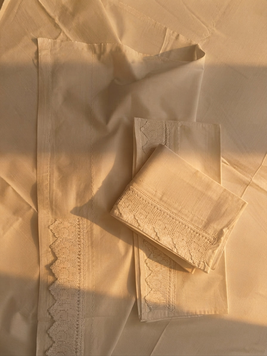 Detail of the white cotton pillowcase showing inset handmade crochet lace along the opening side.