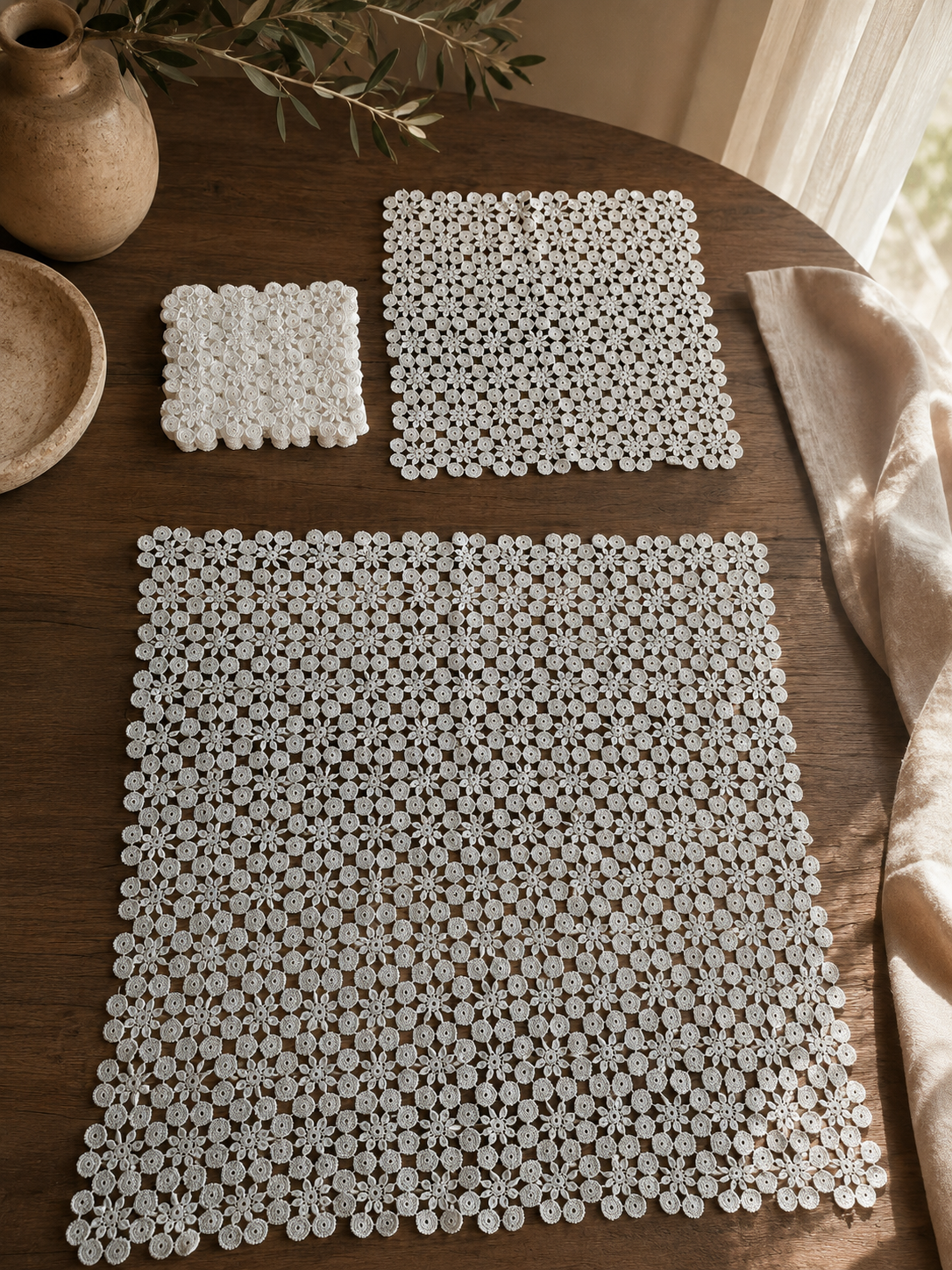Complete thirteen-piece white crochet table-linen set showing the large, medium and eleven small coordinated pieces.