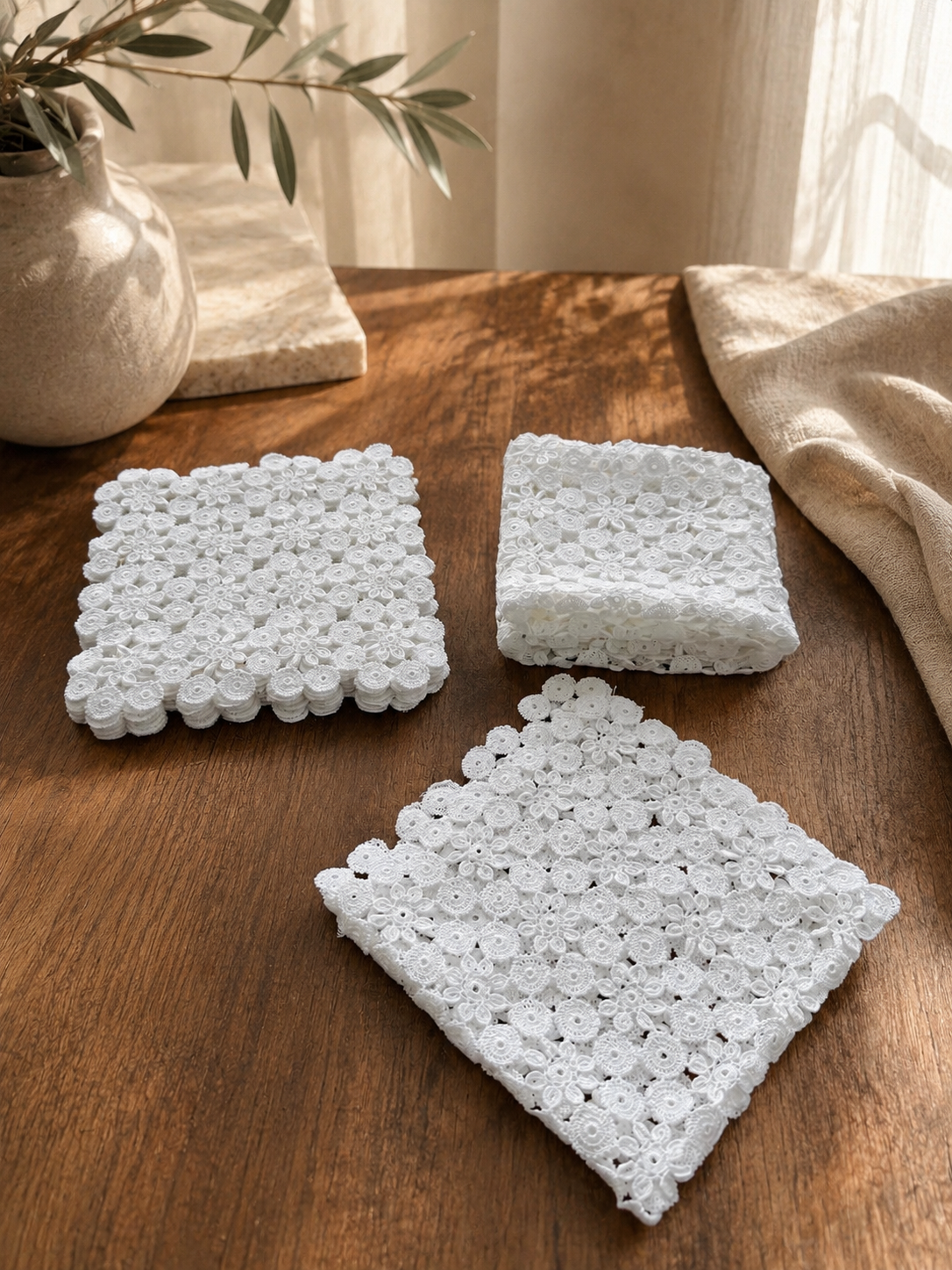 Grouped view of the white crochet doily set showing the three coordinated sizes and repeating floral motif design.