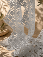 Close view of the white crochet lace border pieces draped vertically to show their pointed edging and handmade texture.