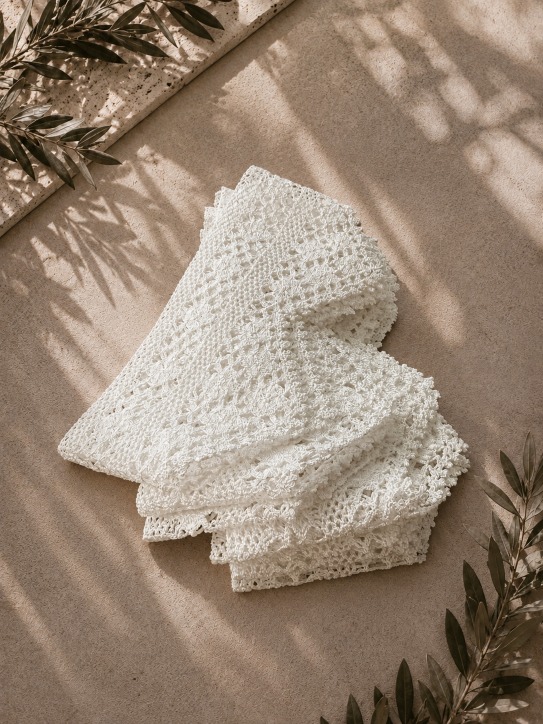 Folded view of the handmade white crochet lace border set styled on a neutral surface with soft shadows.