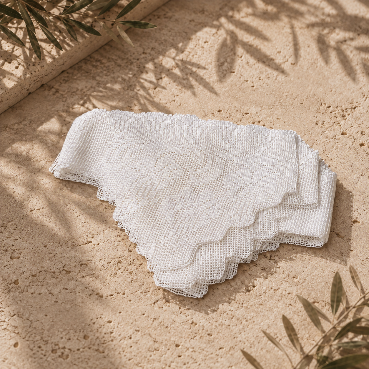 Folded white crochet lace edge pieces showing the layered pointed borders and handmade polyester stitch texture.