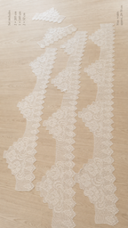Five-piece white crochet lace edge set laid flat to show the stepped repeat sections, pointed borders and different lengths.