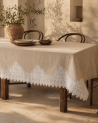 White handmade crochet lace styled around a table textile as a decorative border reference; the tablecloth and furnishings are not included.
