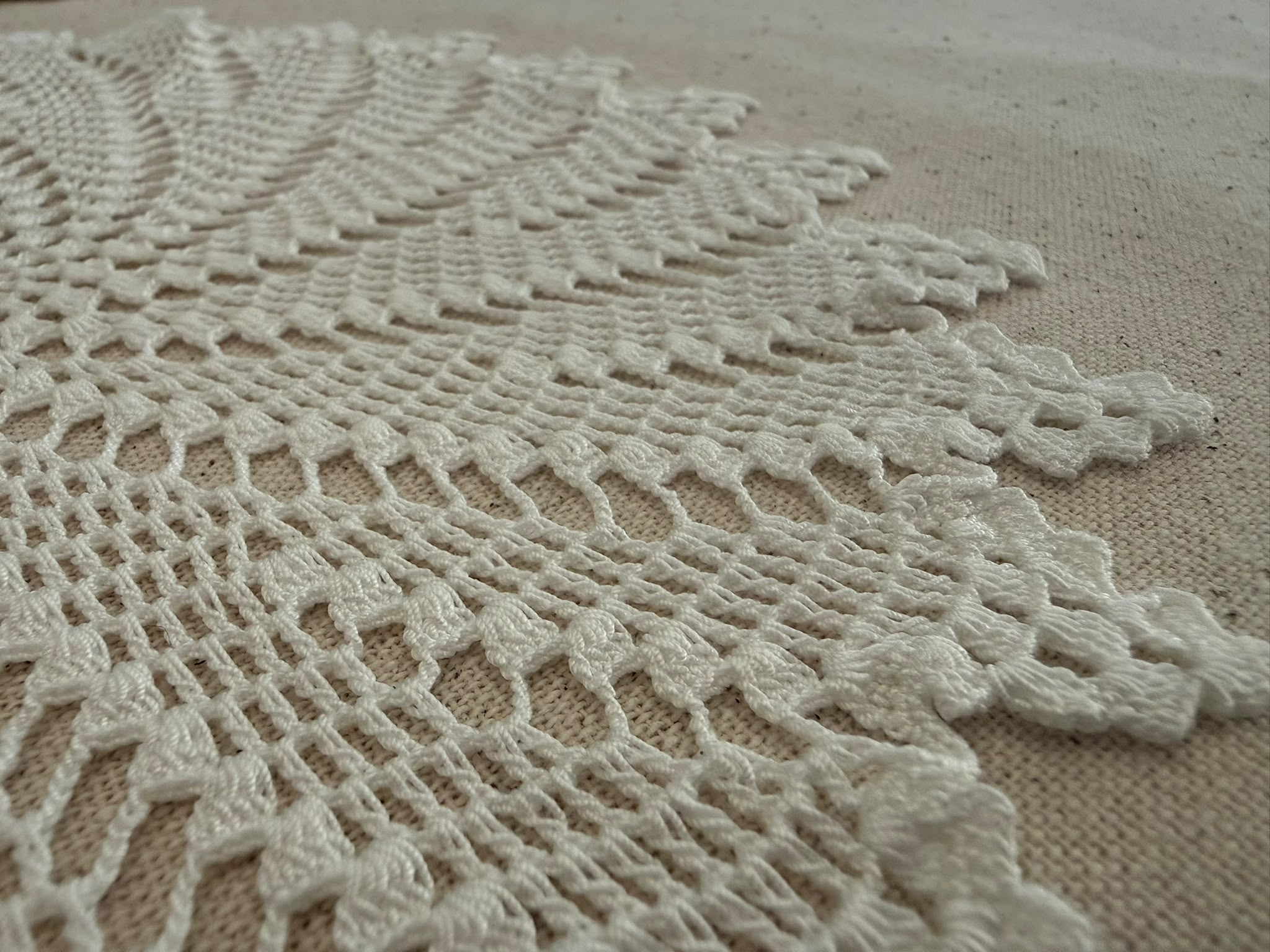 Detailed view of the repeating leaf-shaped sections within the handmade round crochet lace motif.