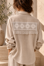 White floral crochet lace panel styled across the back of a beige blouse