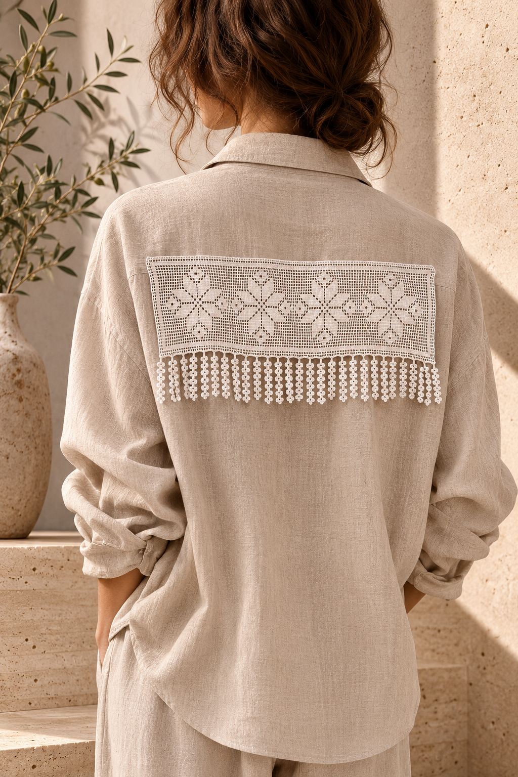 White floral crochet lace panel styled across the back of a beige blouse