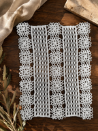Flat-lay view of the specially constructed white crochet panel with motif rows separated by closely worked linear sections.