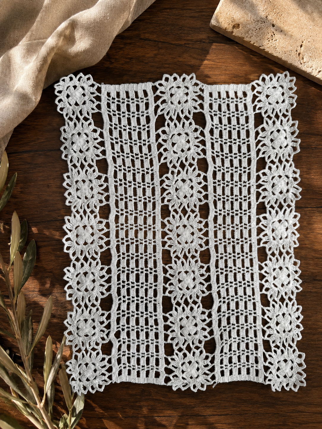 Flat-lay view of the specially constructed white crochet panel with motif rows separated by closely worked linear sections.