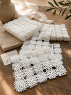 Selection of folded and laid-flat pieces from the nineteen-piece white crochet table-linen collection.