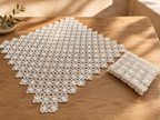 Styled view of the handmade white crochet table-linen set showing the large square centrepiece and smaller matching pieces.