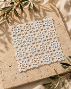 Close view of a small white crochet doily from the seventeen-piece set, showing its joined floral motifs and open lace construction.