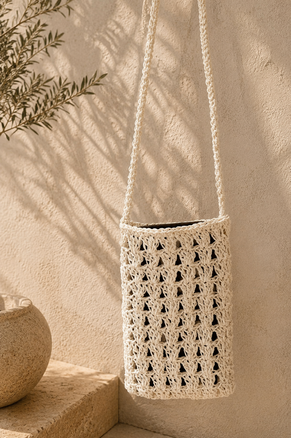 Front view of the white paper yarn crochet phone bag with a long crossbody strap.